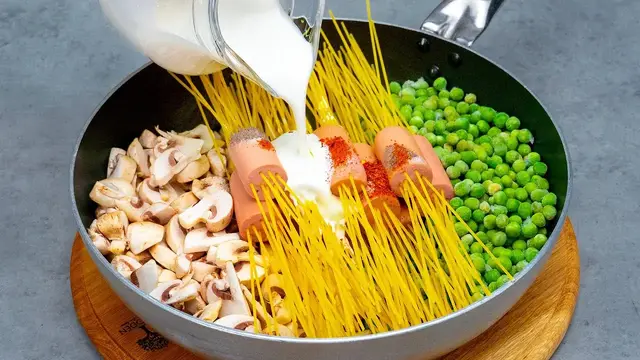 Паста с сосисками и овощами на сковородке