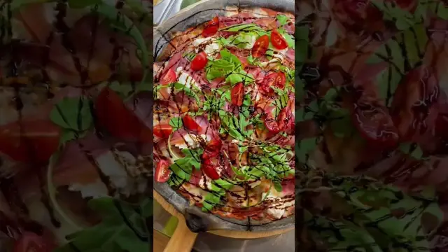 Пицца с чернилами каракатицы, страчателлой, ветчинной, рукколой, томатами и бальзамическим соусом